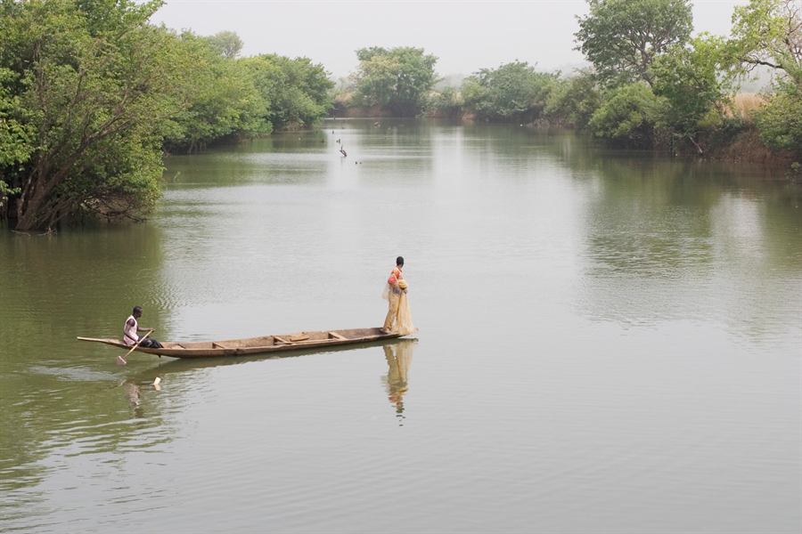Un pêcheur lançant un filet depuis une pirogue sur le Niger